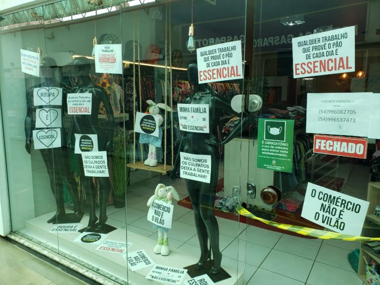 Lojistas colocam manequins com cartazes de protestos em vitrines de Serafina Corrêa